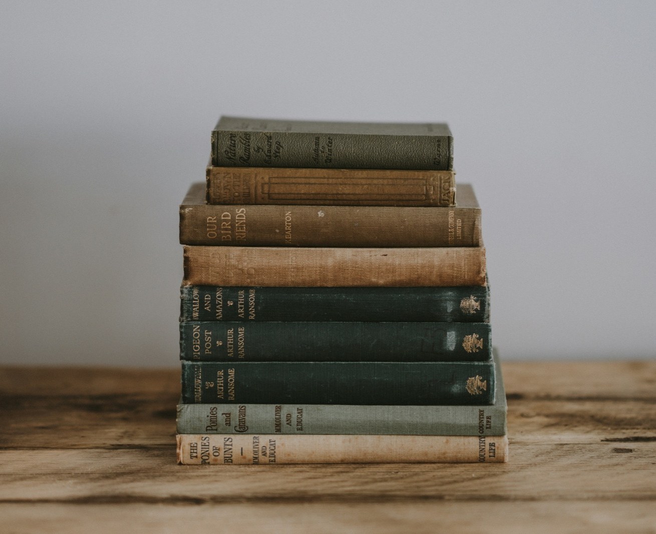 a stack of worn vintage hardcover books